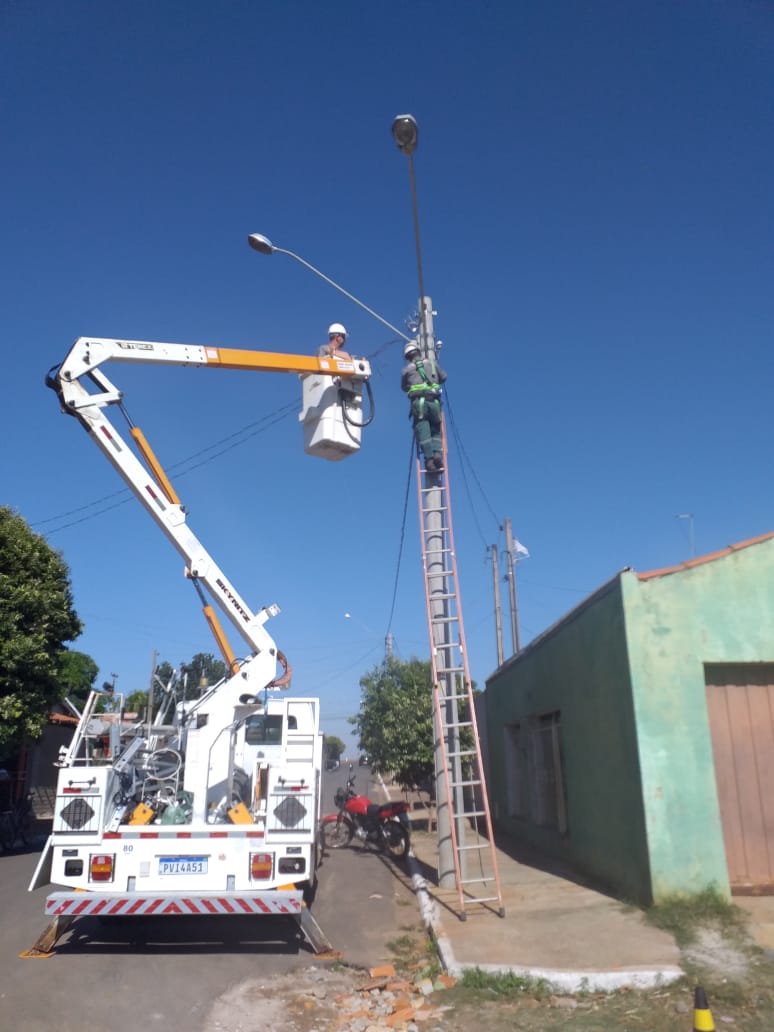 Equipe executando instalação e manutenção de iluminação pública com cesto aéreo